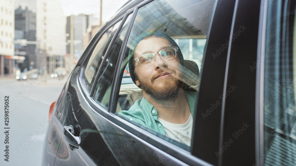 Stylish Young Man Rides on a Passenger Back Seat of a Car, Looks out of the Window in Wonder. Big Ci