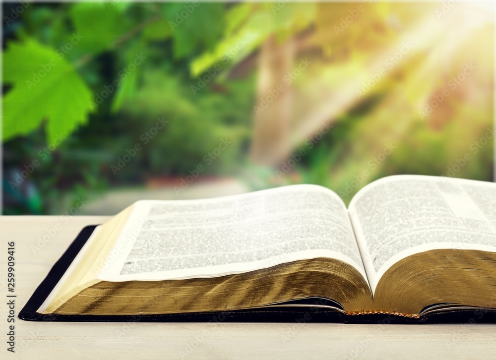 Open book on old wooden table.