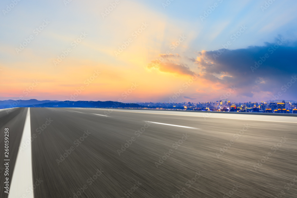 Motion blurred asphalt road passing through the city above in Hangzhou at sunset