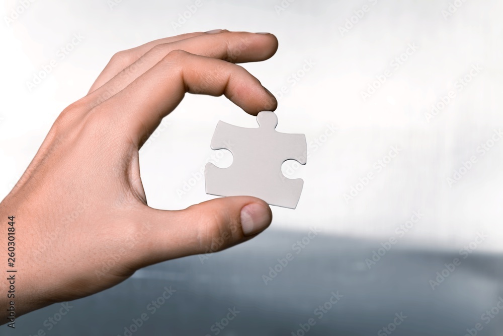 Human hands joining puzzle parts on background