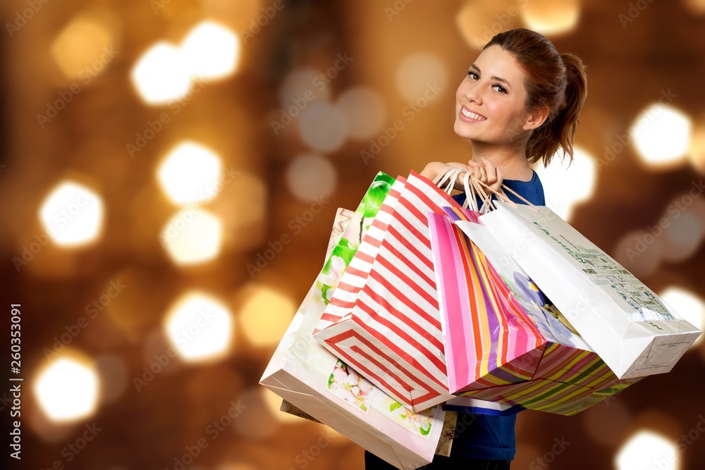 Young woman with shopping bag on blurred shopping mall background