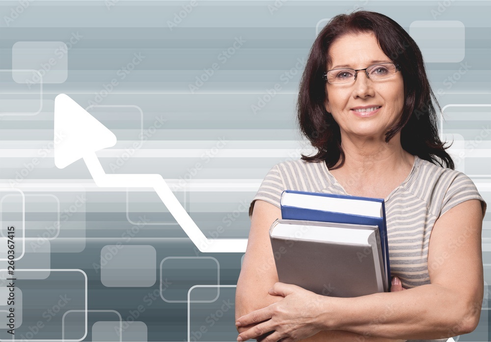 Mature woman teacher with books on background