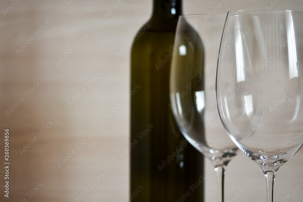 Bottle of wine and wine glass stemware in the simple interior of the apartment