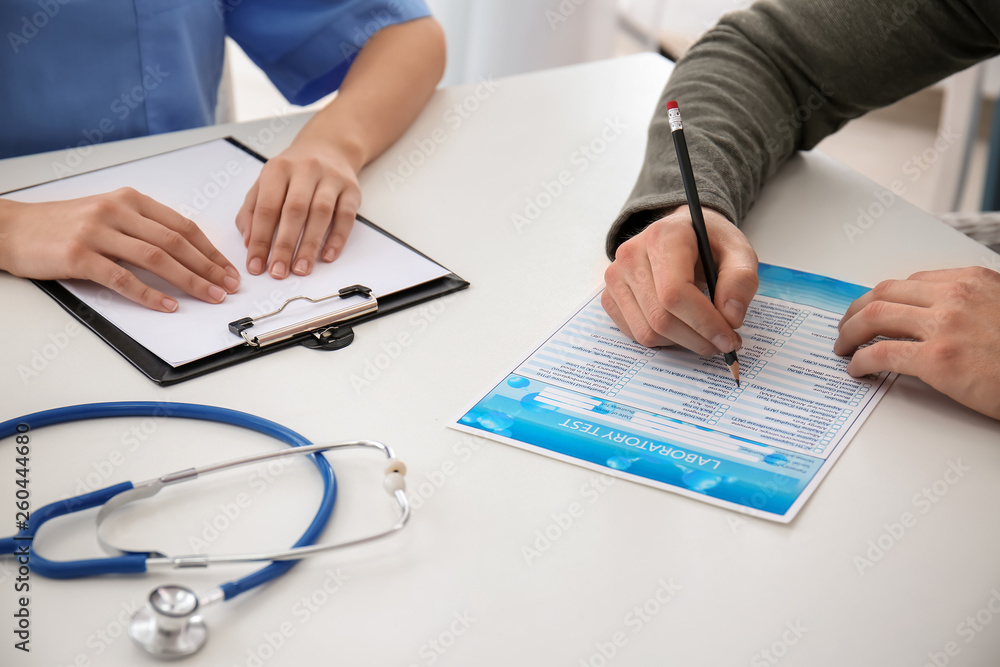 Female doctor working with male patient in clinic