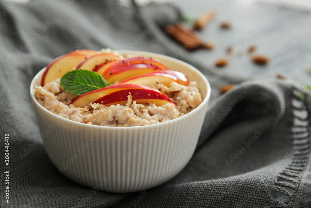 Bowl with tasty sweet oatmeal on table