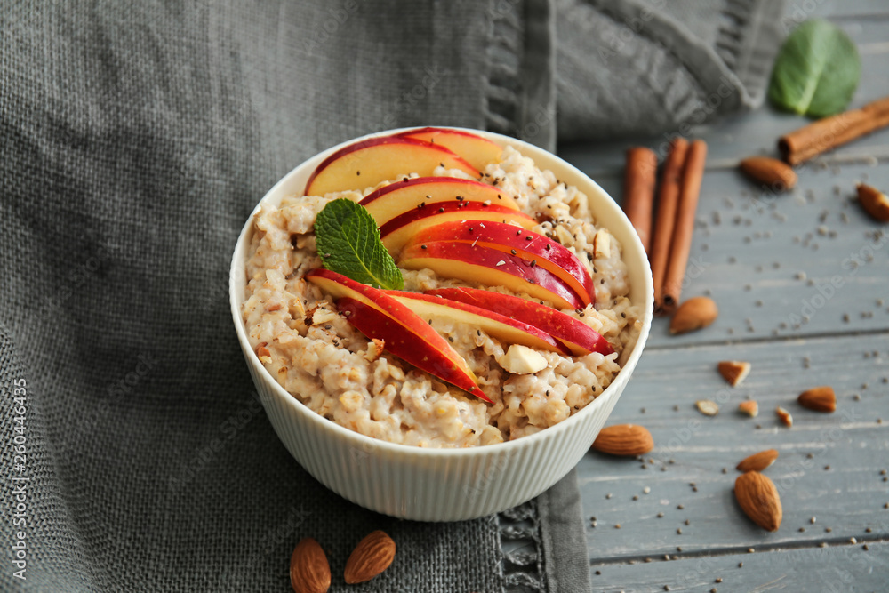 Bowl with tasty sweet oatmeal on table