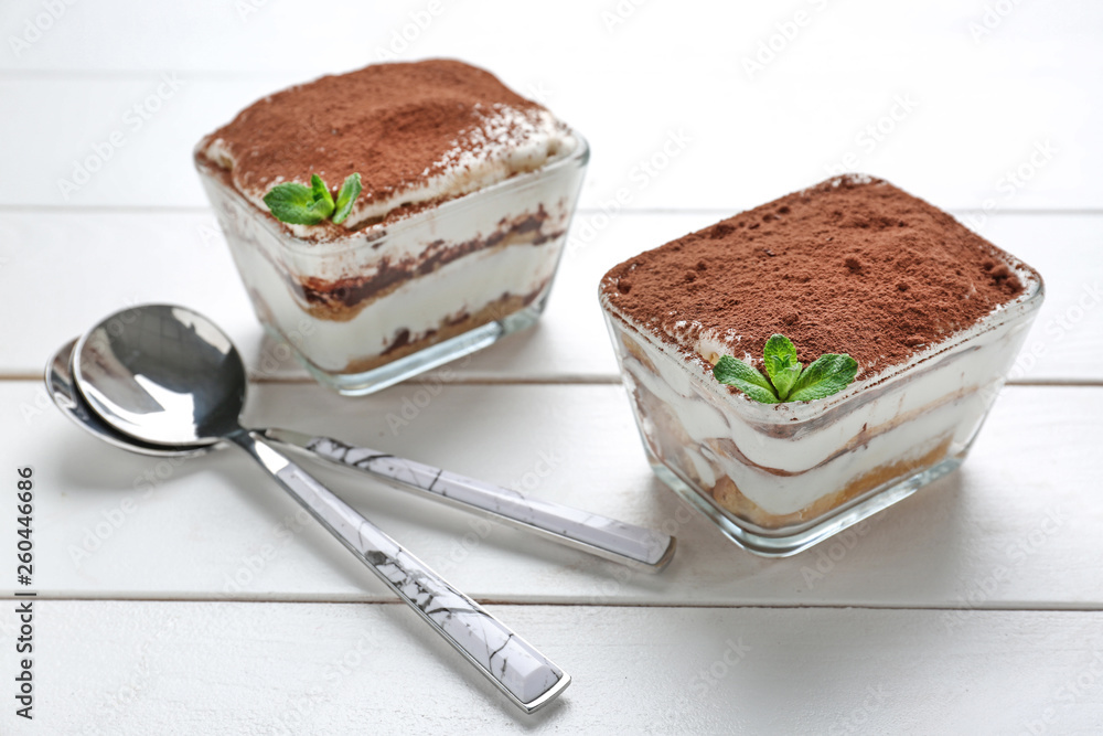 Tasty tiramisu on white wooden table