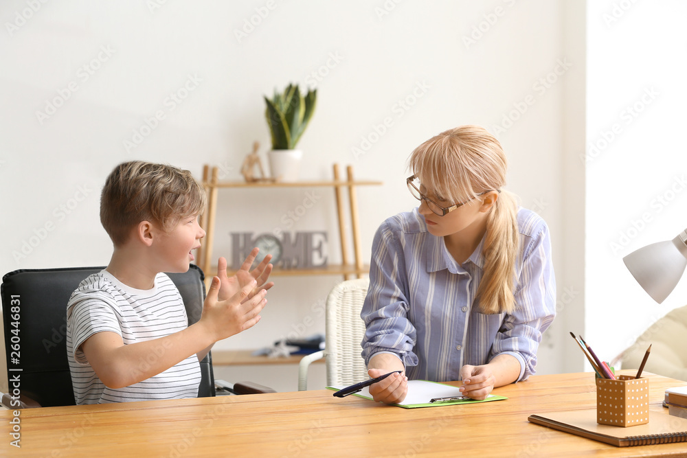 Female psychologist working with little boy in office