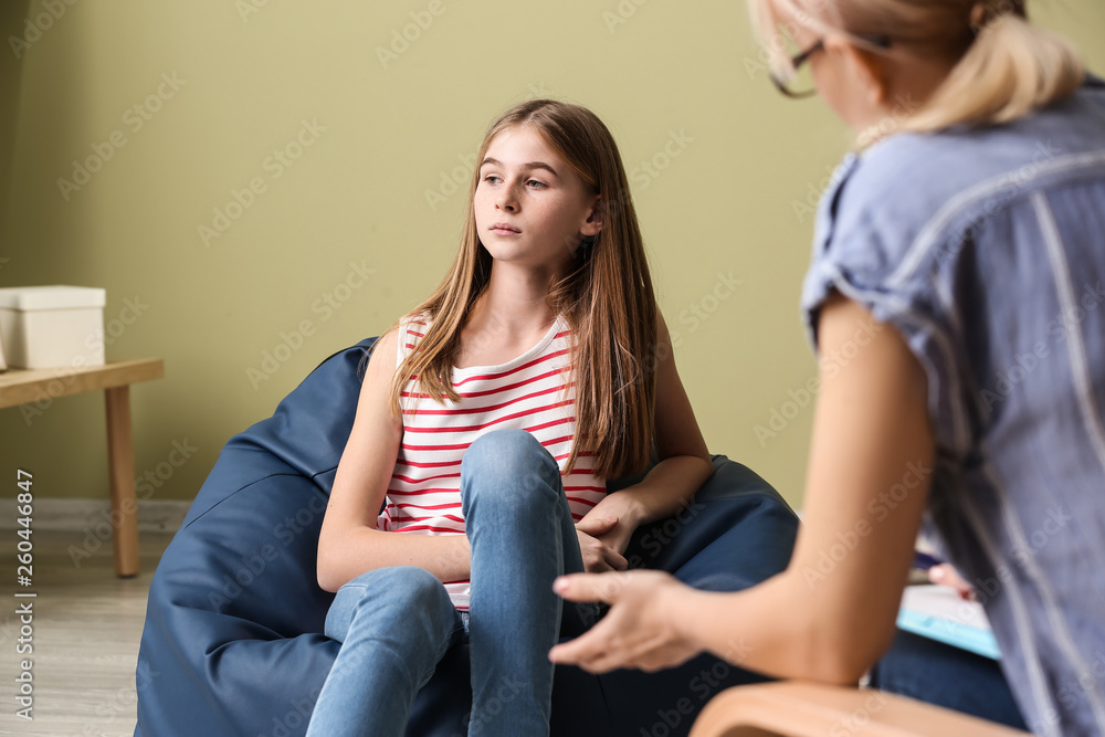 Female psychologist working with teenage girl in office