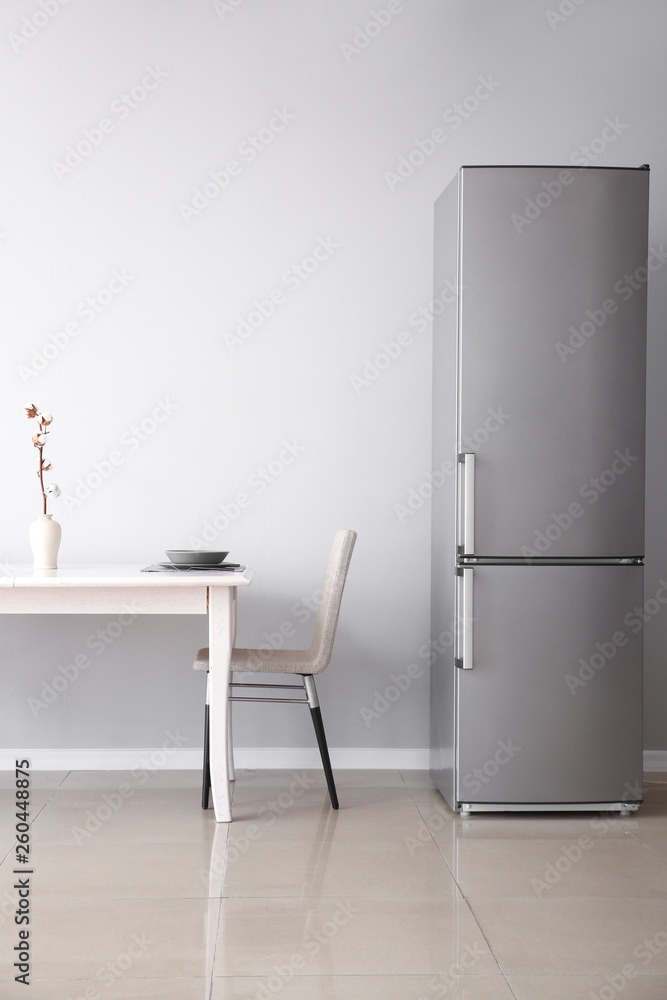 Modern fridge and served table in kitchen