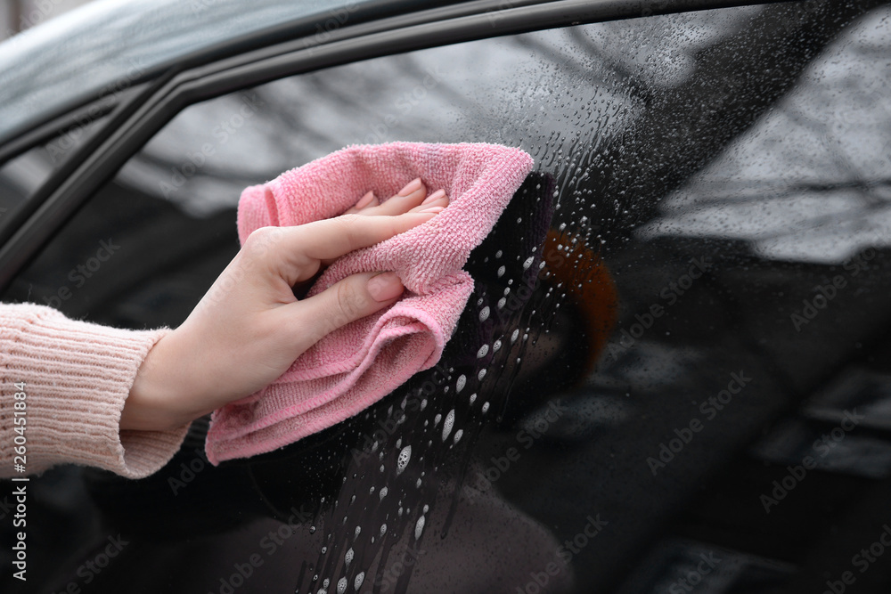 Woman cleaning car window