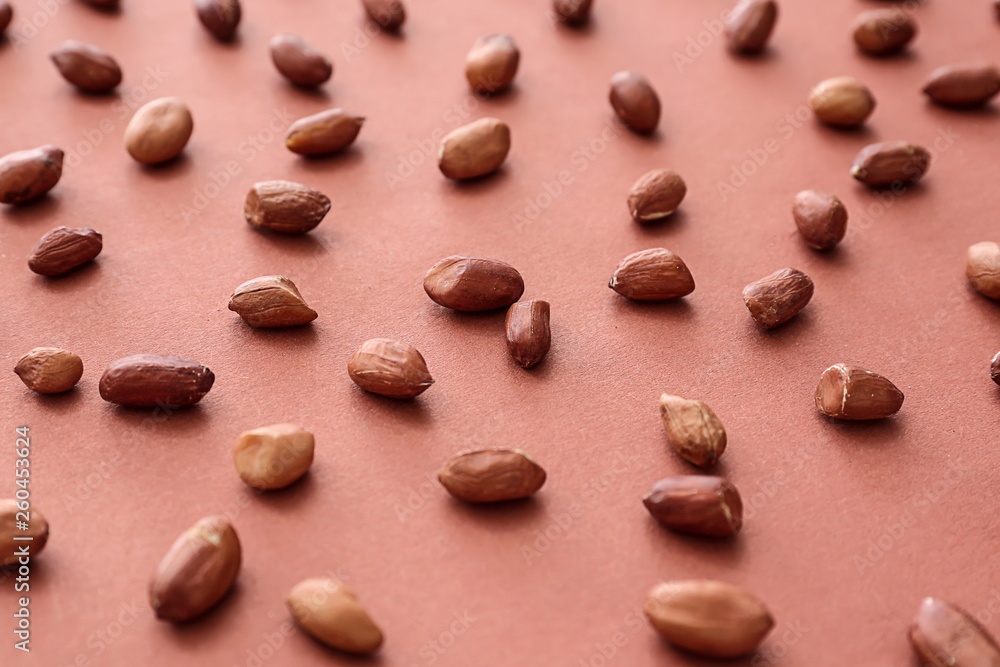 Tasty peanuts on color background