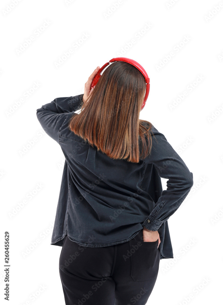 Young woman with headphones listening to music on white background