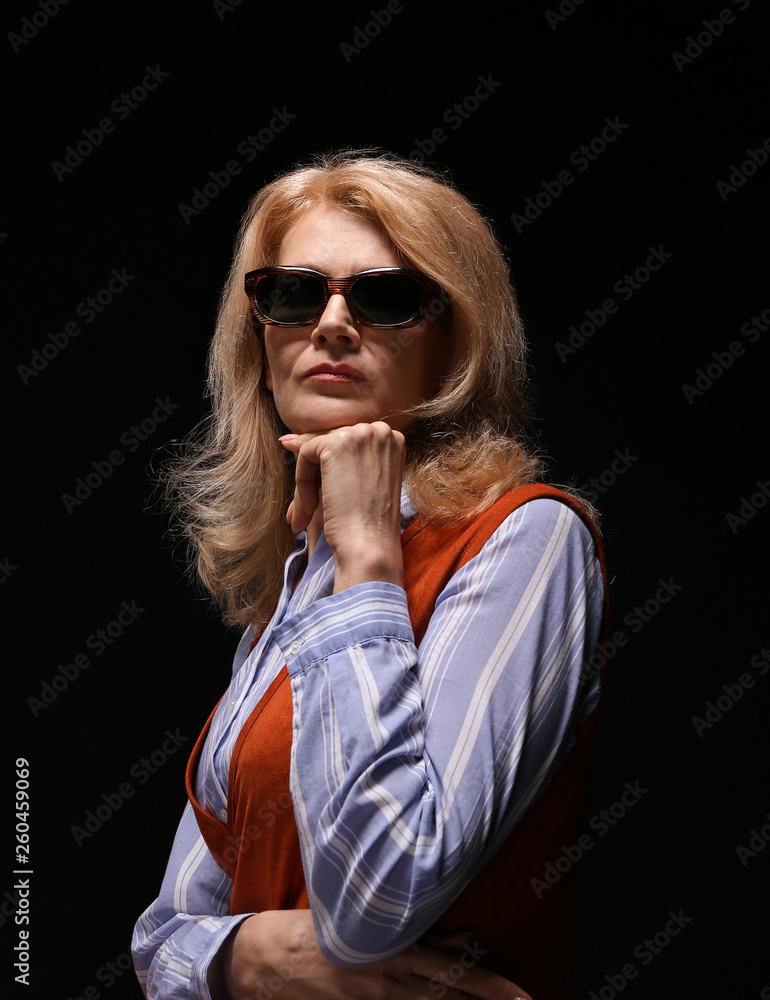 Stylish mature woman on dark background