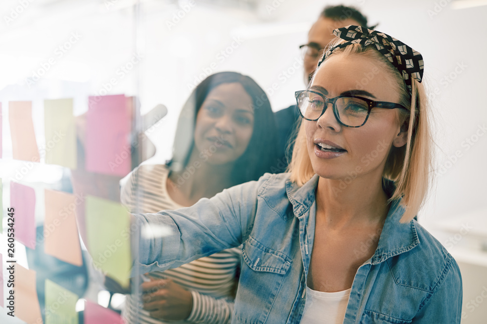 Young businesswoman brainstorming with her team in a modern offi