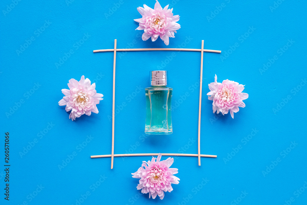 air freshener sticks with flowers on blue background top view