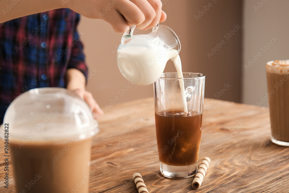 女人在木桌上准备美味的frappe咖啡