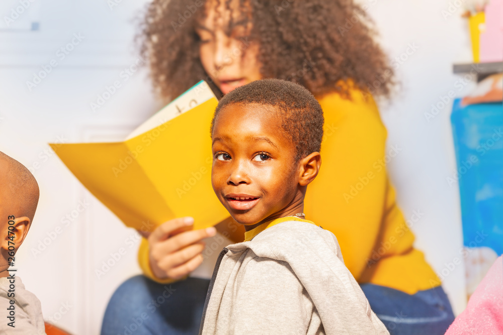 Little boy portrait with woman reading book