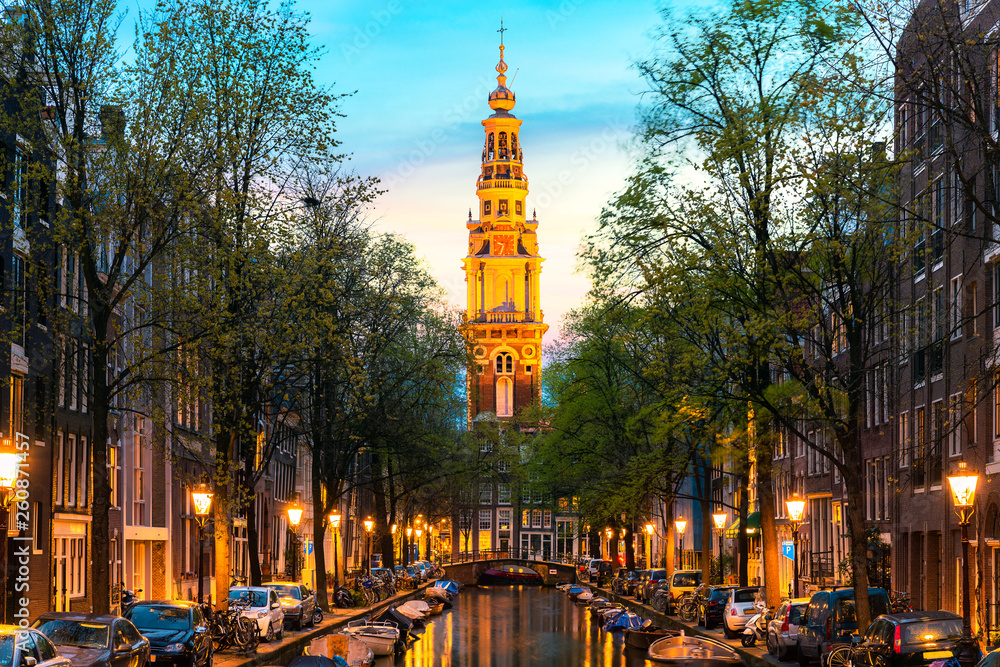 Amsterdam Zuiderkerk church tower at the end of a canal in the city of Amsterdam, Netherlands at nig