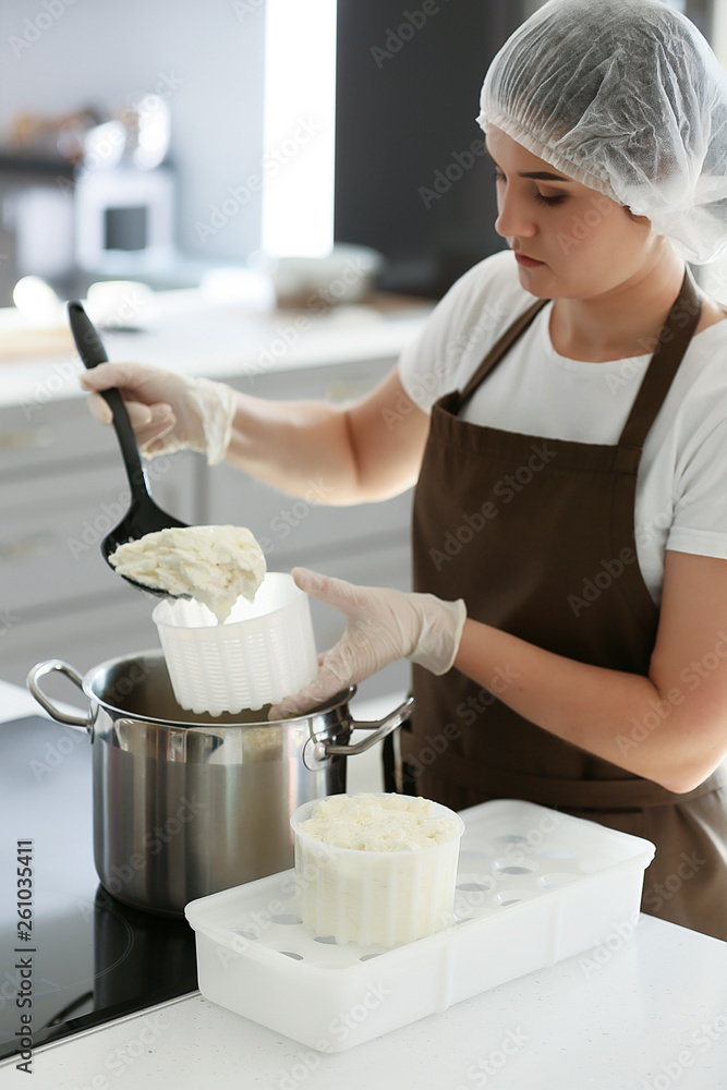 Woman preparing tasty cheese in kitchen