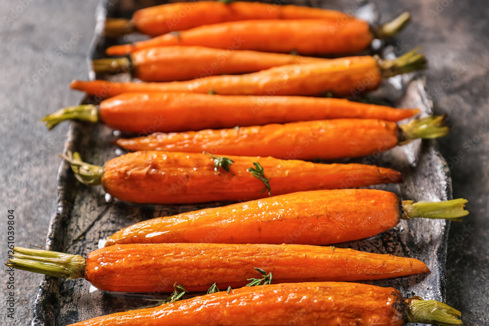 Plate with tasty cooked carrot on table, closeup