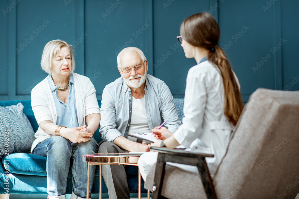 Senior couple sitting with nurse during the medical consultation in the comfortable office