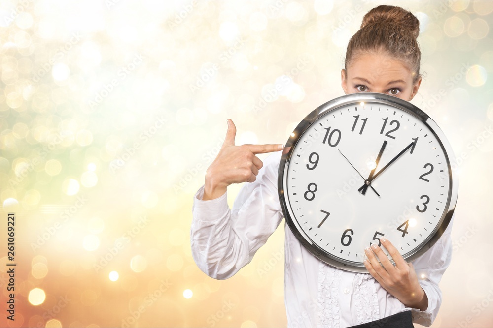 Frustrated young businessman holding an alarm clock