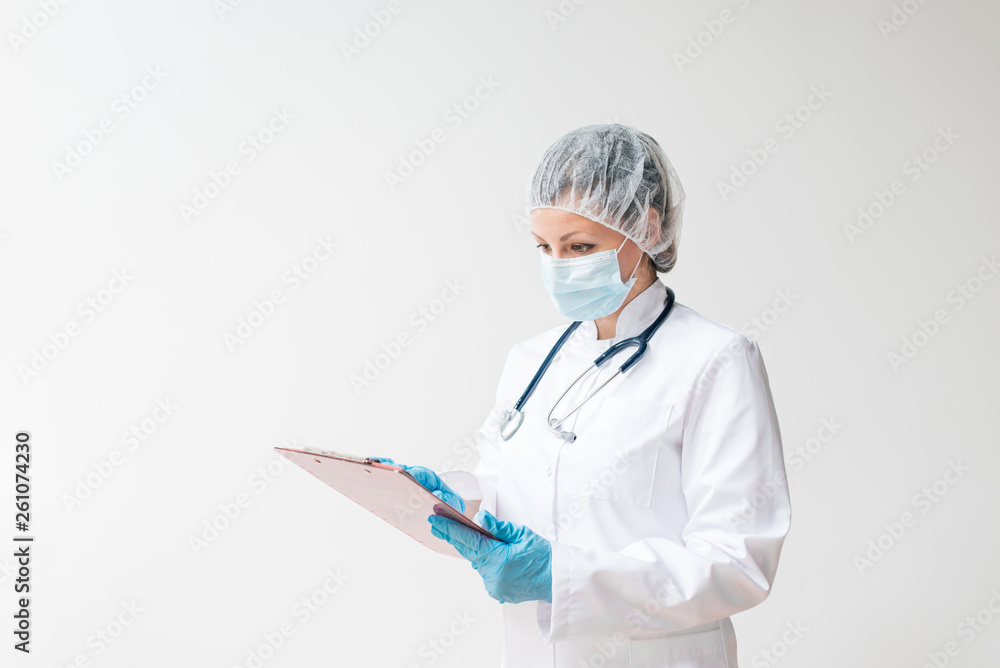 Portrait of female doctor in protective wear looking at patients chart.