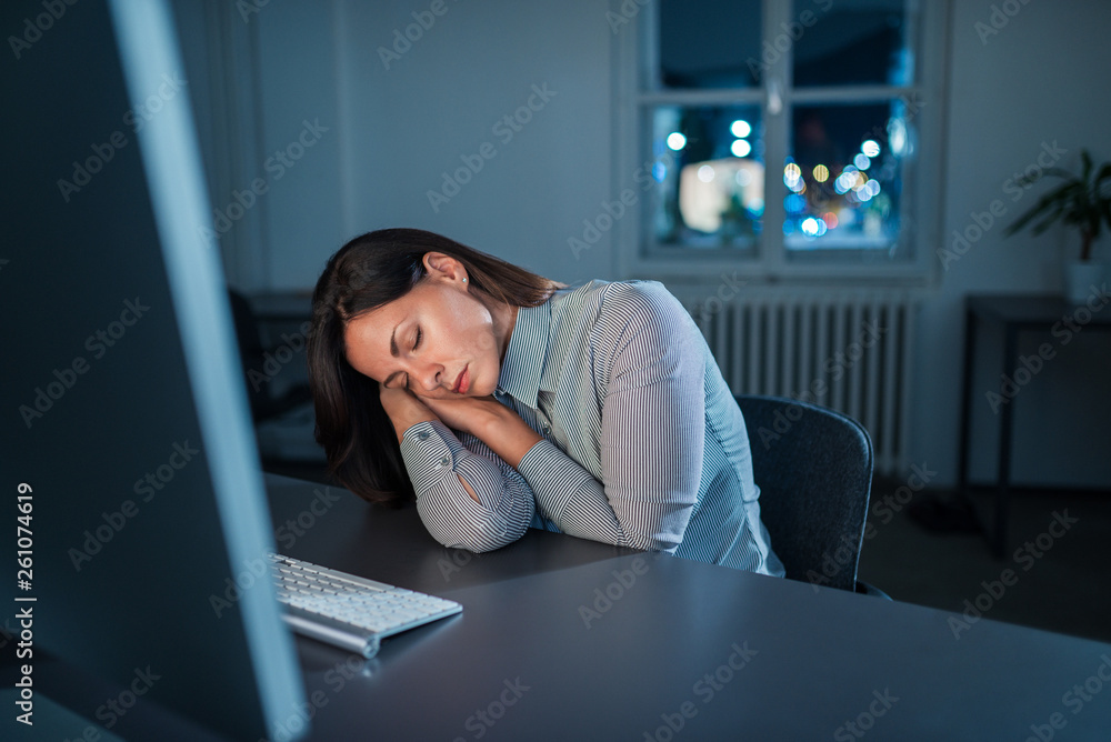 Overworked woman sleeping at workplace.