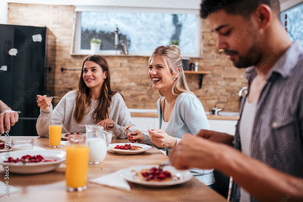 Young people in casual clothing are eating together on winter vacation.