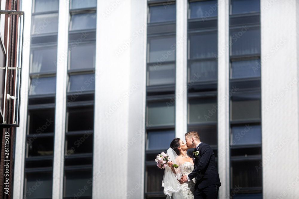 Bride and groom walking in the city, wedding day, marriage concept. Bride and groom in urban backgro