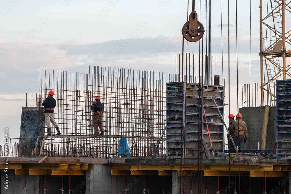 construction workers fix steel bars at a construction site