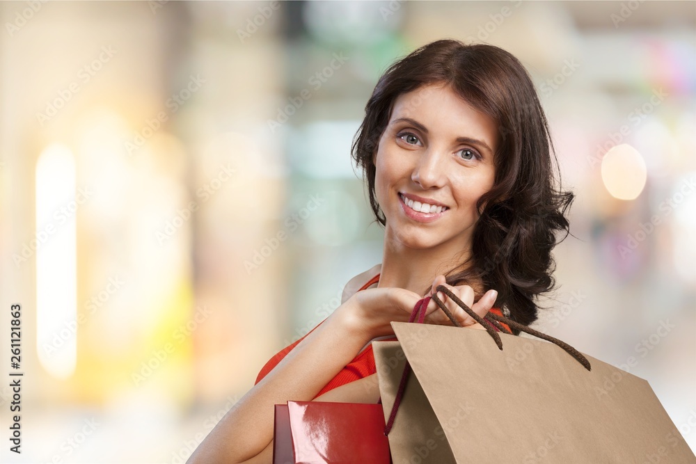 Young woman with shopping bags on blurred shopping mall background