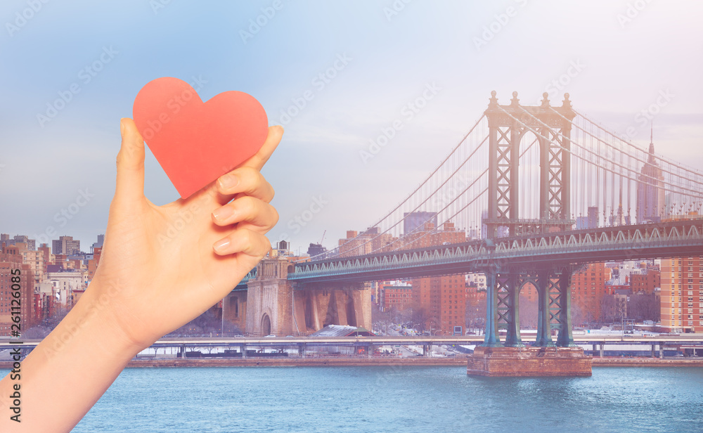 Hand hold red heart over Brooklyn Bridge  New York