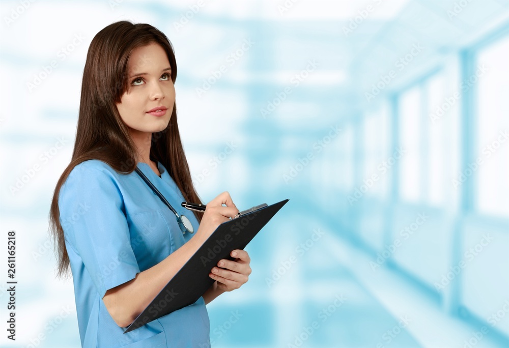 Young doctor portrait at blurred hospital background, bokeh