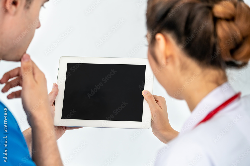 Female doctor using tablet computer while discussing with another doctor at the hospital. Medical he