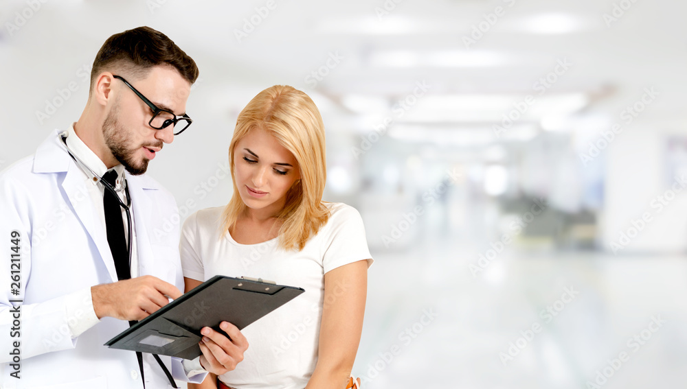 Doctor talking to patient in the hospital. The happy patient is listening to explanation from the do