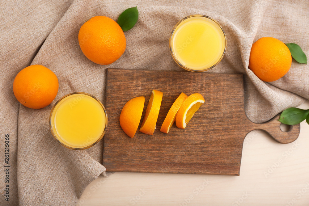 Glasses of freshly squeezed orange juice with cutting board on table