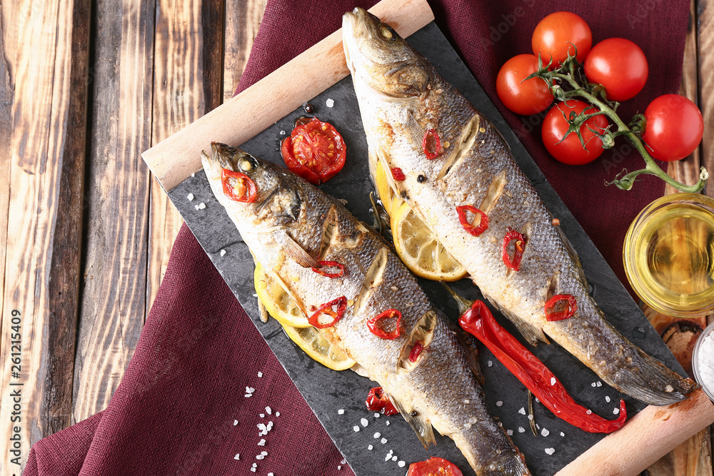 Tasty cooked fish on wooden table