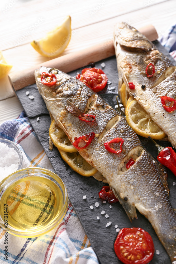 Tasty cooked fish on white wooden table