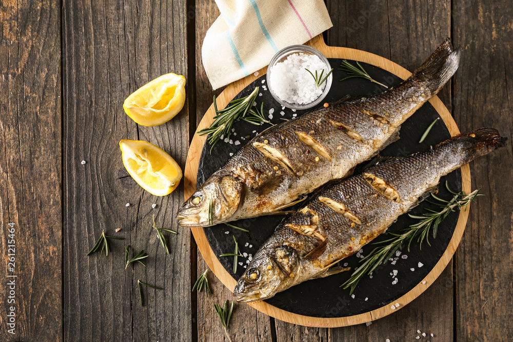 Tasty cooked fish on wooden table