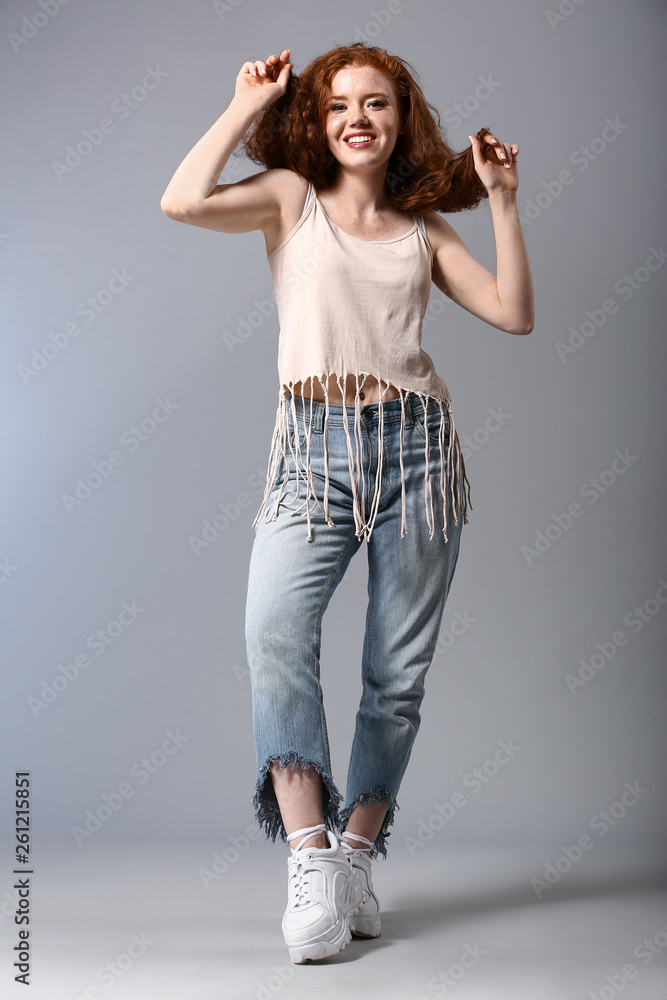 Portrait of fashionable young woman on grey background