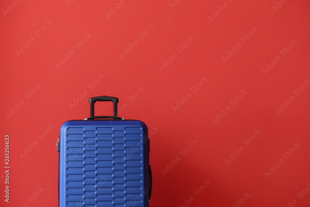 Packed suitcase on color background