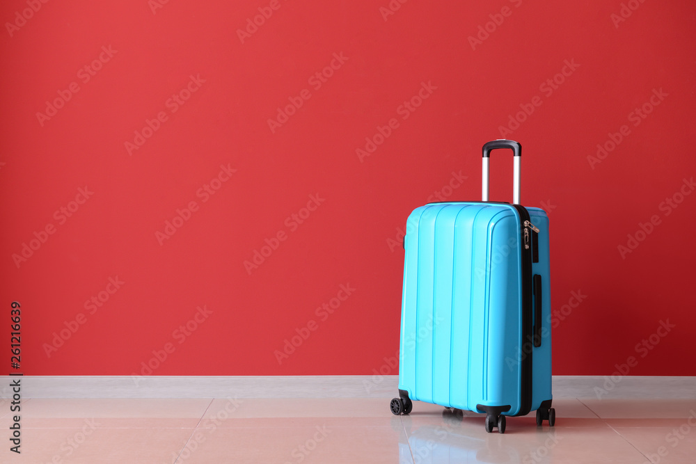 Packed suitcase near color wall