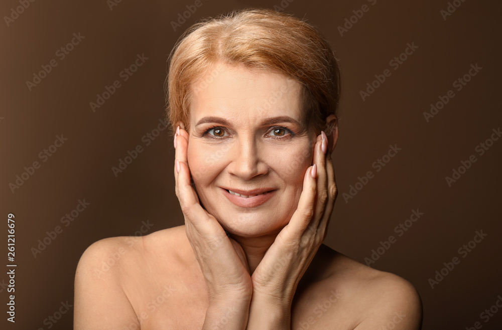 Portrait of beautiful mature woman on color background