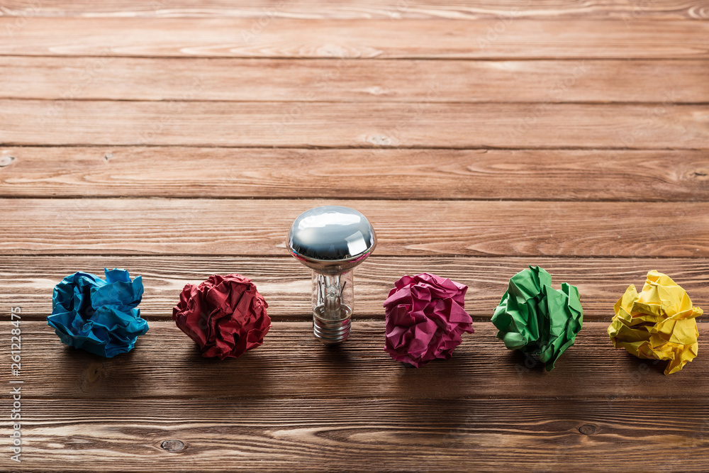 Ideological concept with wastepaper light bulb on wooden table