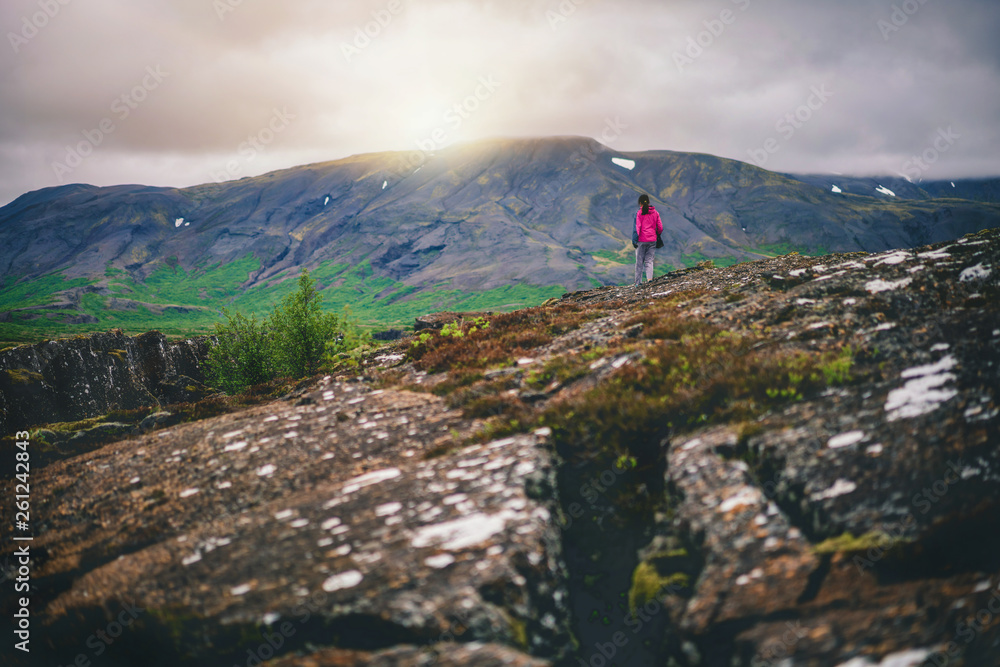 Woman traveler and explorer travels in the Icelandic landscape hiking across Iceland to discover uni