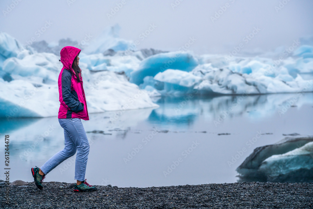 Woman traveler travels to Jokulsarlon beautiful glacial lagoon in Iceland. Jokulsarlon is a famous d