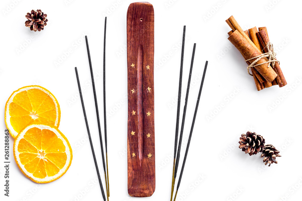 air freshener sticks with cinnamon and orange on white background top view