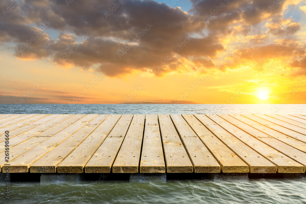 Wooden floor platform and blue sea with sky background